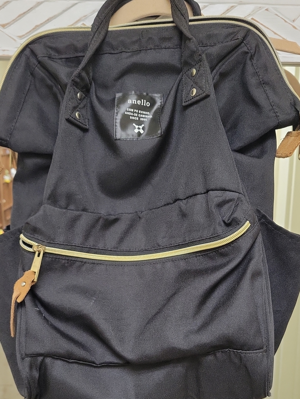 black anello backpack featuring gold-colored zippers.